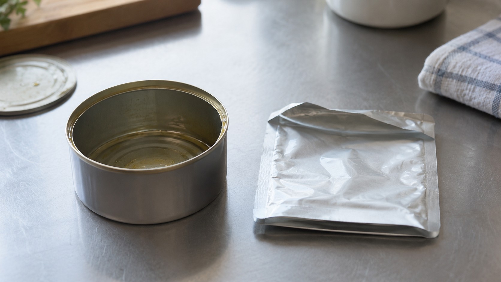 食べ終わった空き缶と、平たく折りたたんだパウチ
